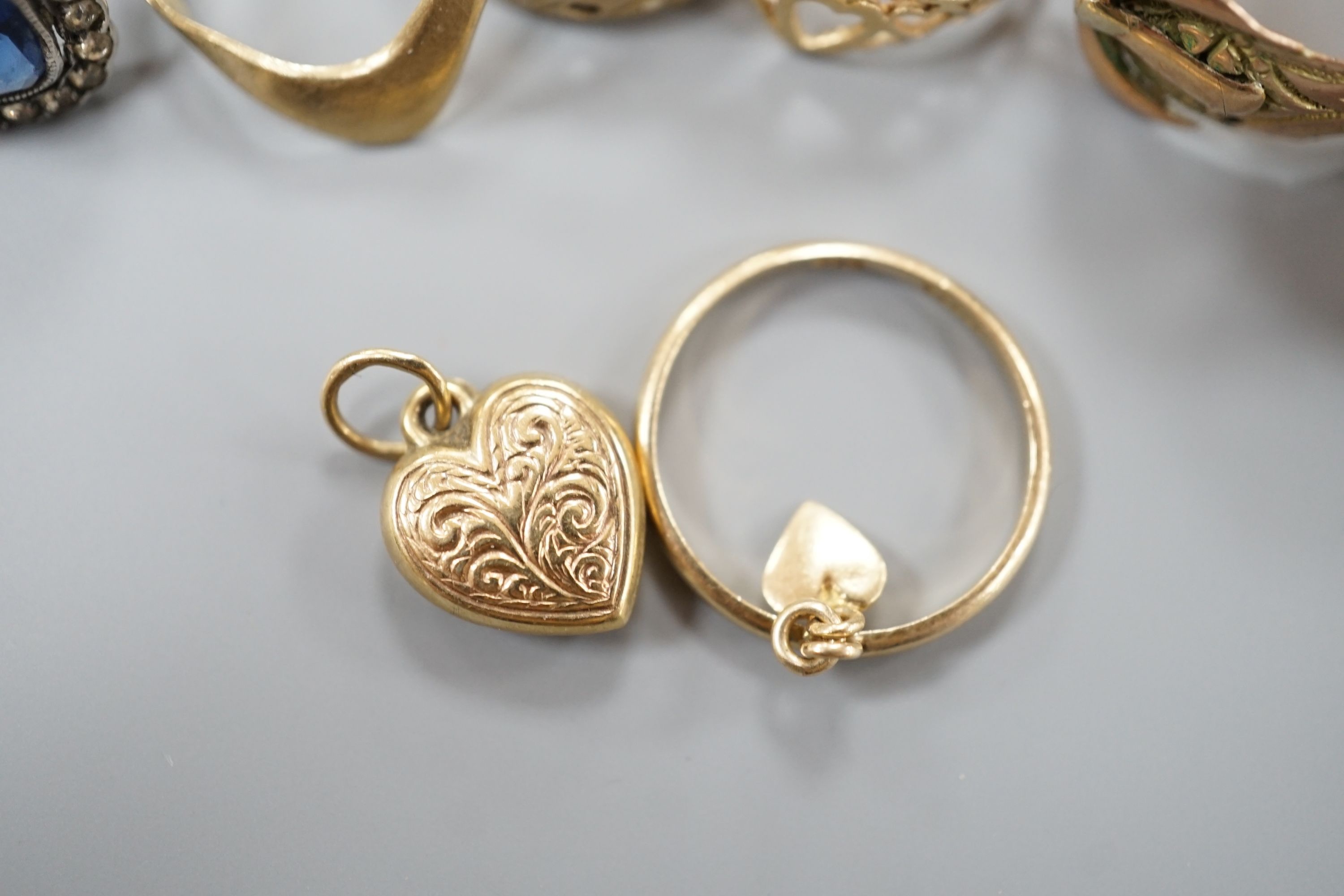 Four assorted 9ct gold rings, a 9ct gold heart pendant and a 9ct and paste set ring, gross 8.3 grams, an Edwardian 18ct gold ring, 4.4 grams and a yellow metal ring, 4 grams.